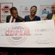 Executive Director of CDEMA Ronald Jackson hands over a cheque for a National Emergency Communication Network