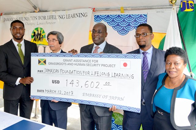 Ruel Reid and Japan’s Ambassador to Jamaica Masanori Nakano display cheque
