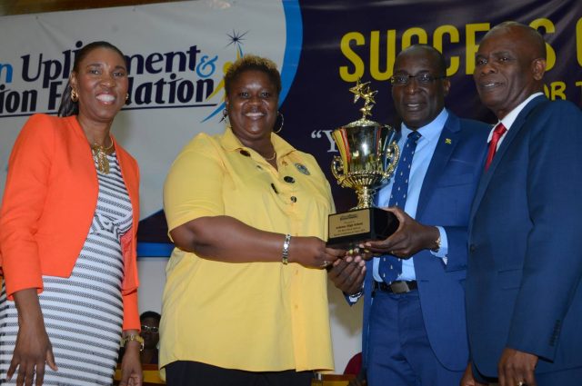 Ruel Reid (third left), presents a trophy to Personal Development Teacher at Ardenne High School, Kamika McKellop (second left), after the school emerged winner of last year’s Best School Spirit and career choices